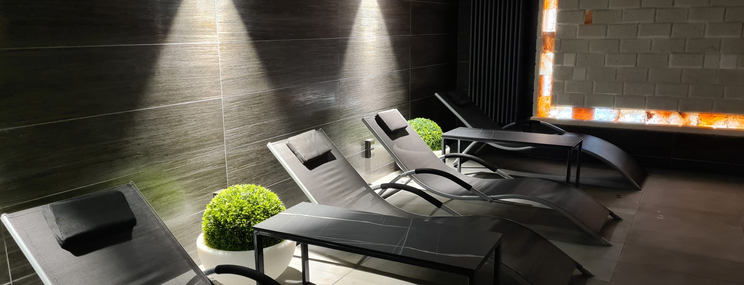Representative salt-room relaxation area with reclining chairs beside an illuminated salt feature